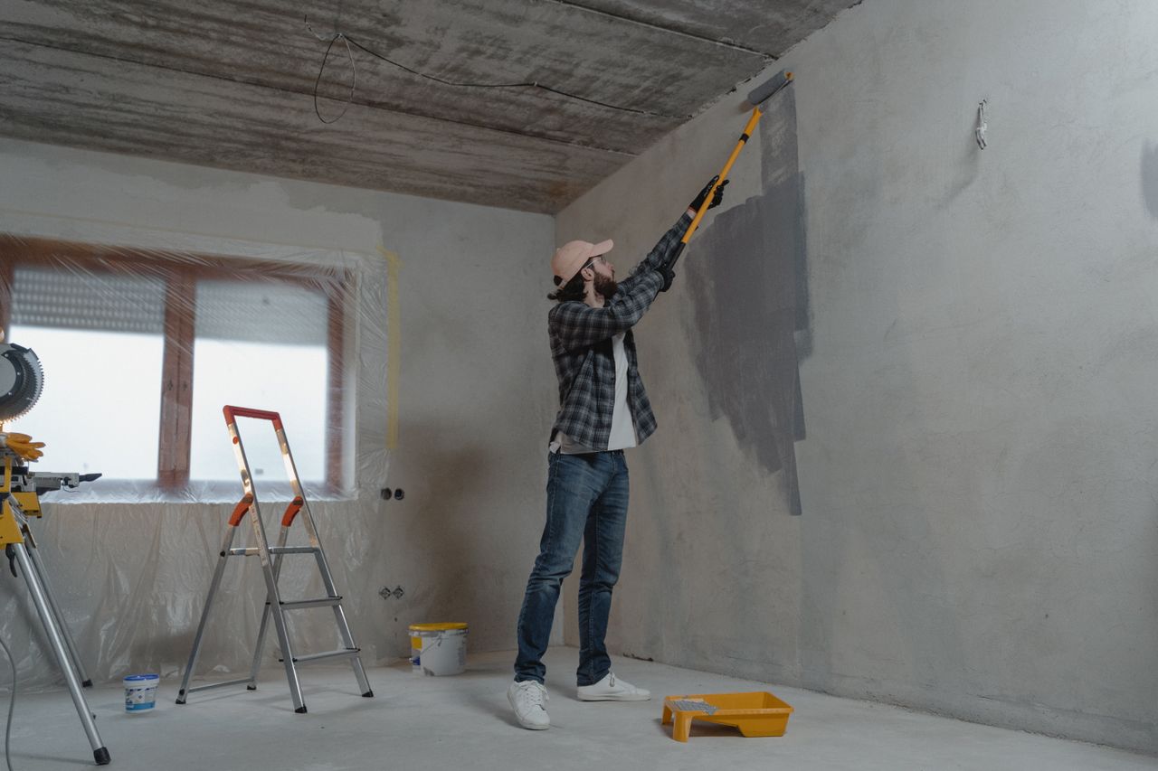 Home mid-renovation while deciding between fix-and-list and a cash sale. Person painting. Image by Pexels