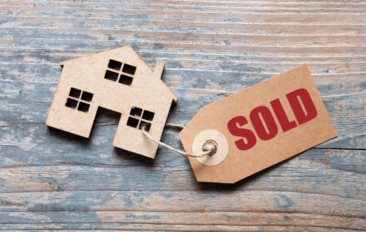 sold tag on a wooden house