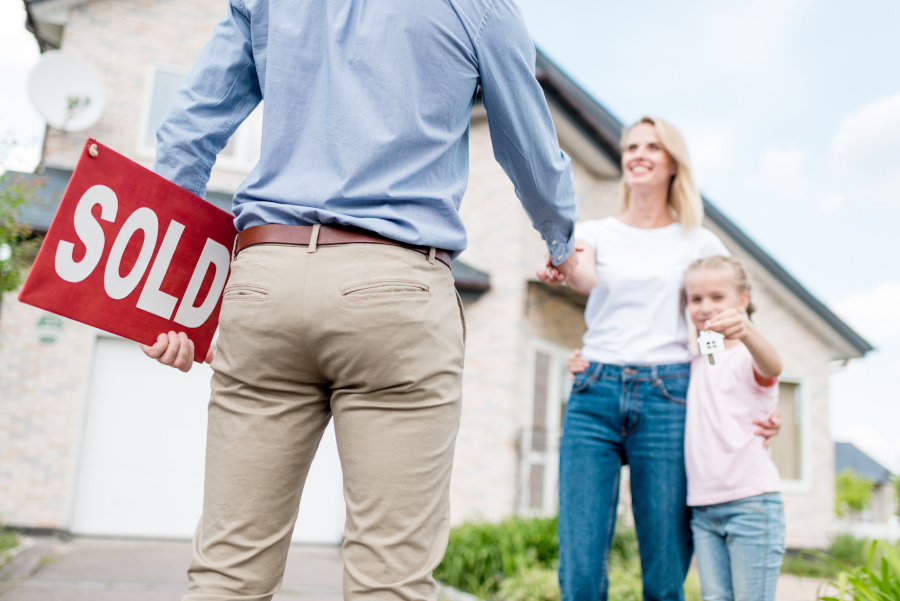 Person holding a for sla sign, shaking hands with a women, girl holding keys