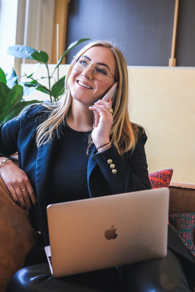 person on the phone with a laptop on her lap