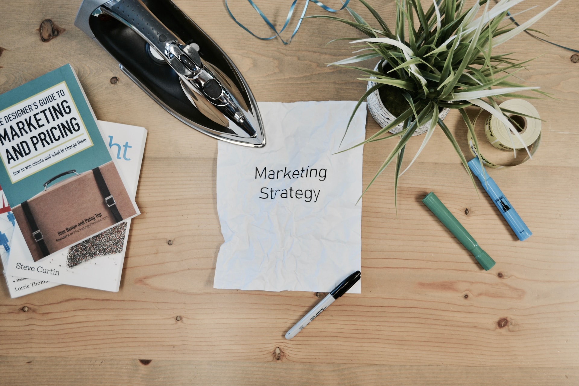 books on a table, iron, paper that says marketing strategy