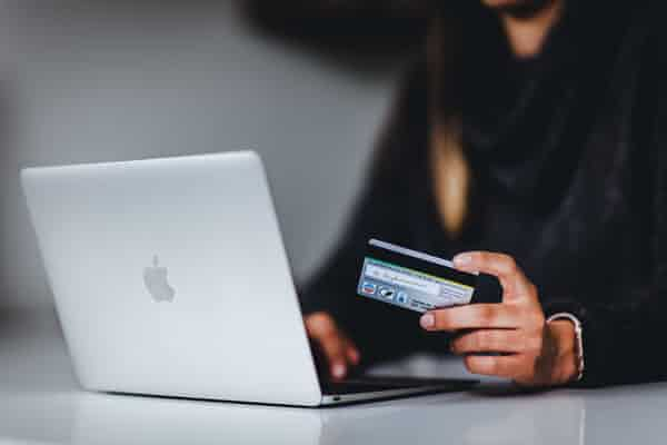 Person with a credit card in front of a computer