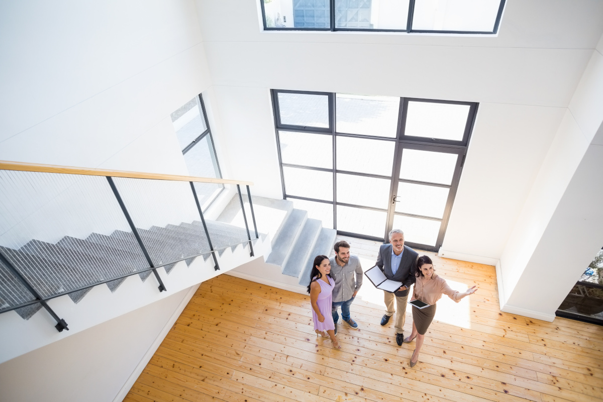 Four people next to a staircase. Looking at a house for sale