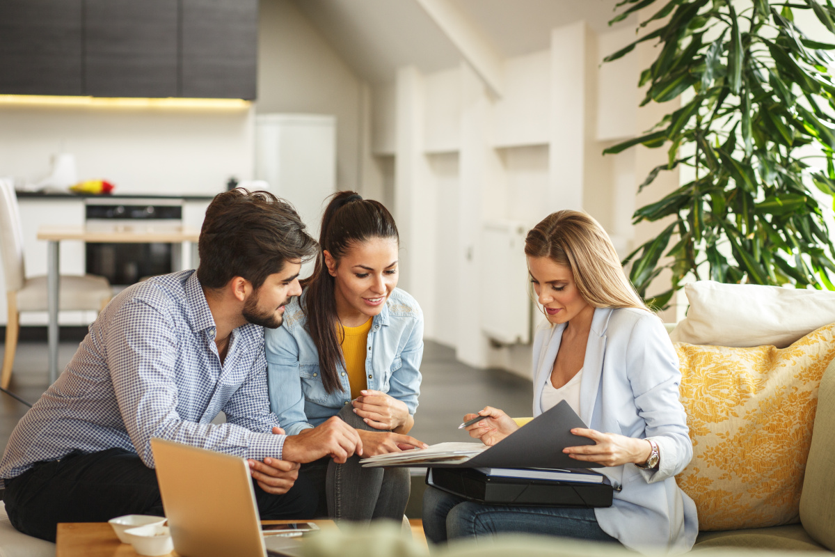 Three people sitting down, looking at paperwork