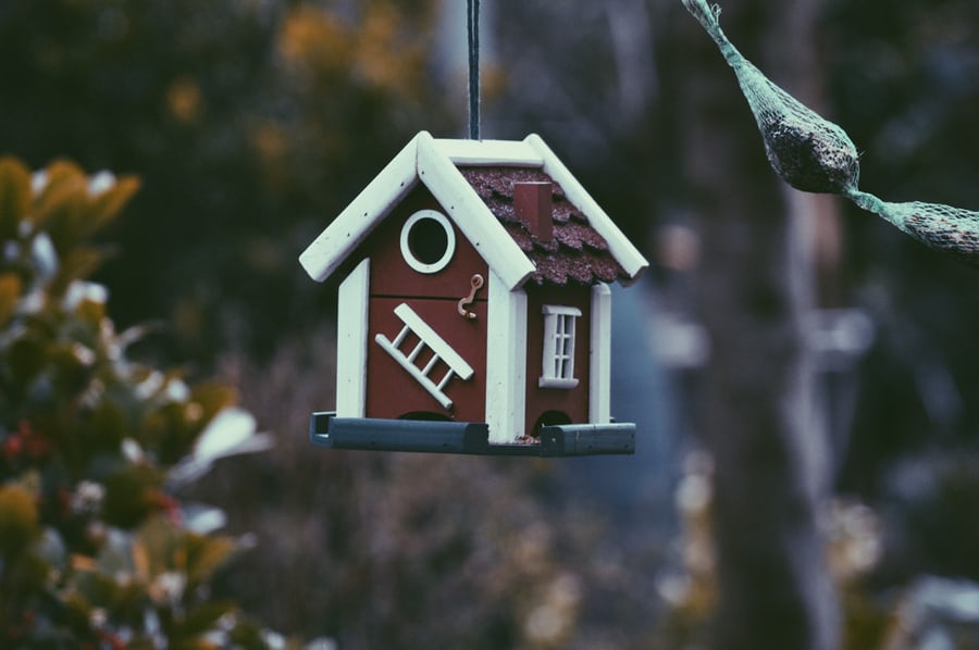 a red birdhouse with white trims