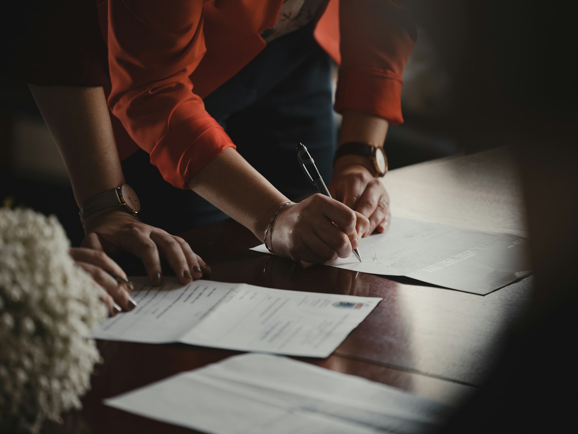 Person signing papers. Image by Unsplash