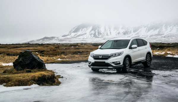 white car on ice, snowly mountain in the background