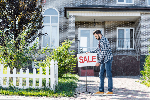 Person Putting up a Sale Sign