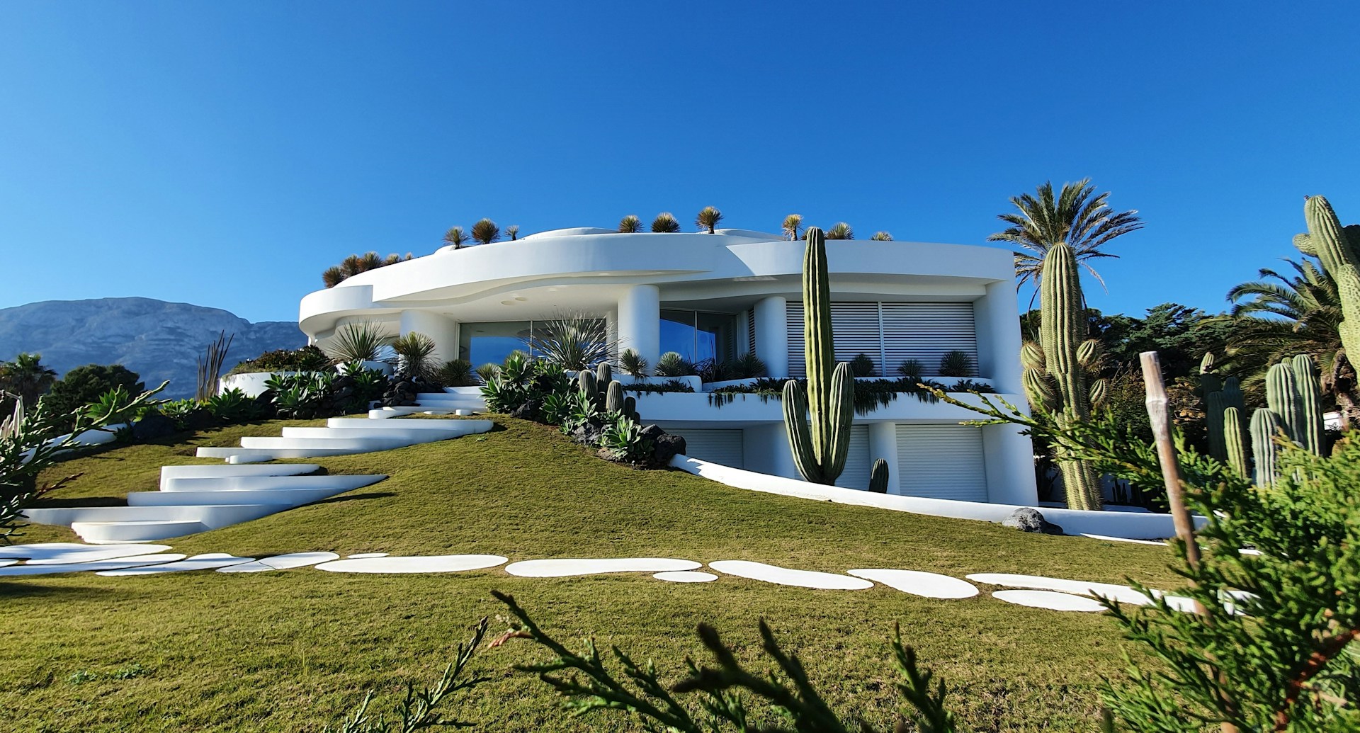 White concrete house, blue sky. Image by Unsplash