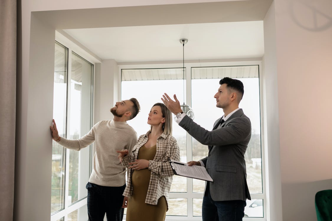 3 people loking at a house