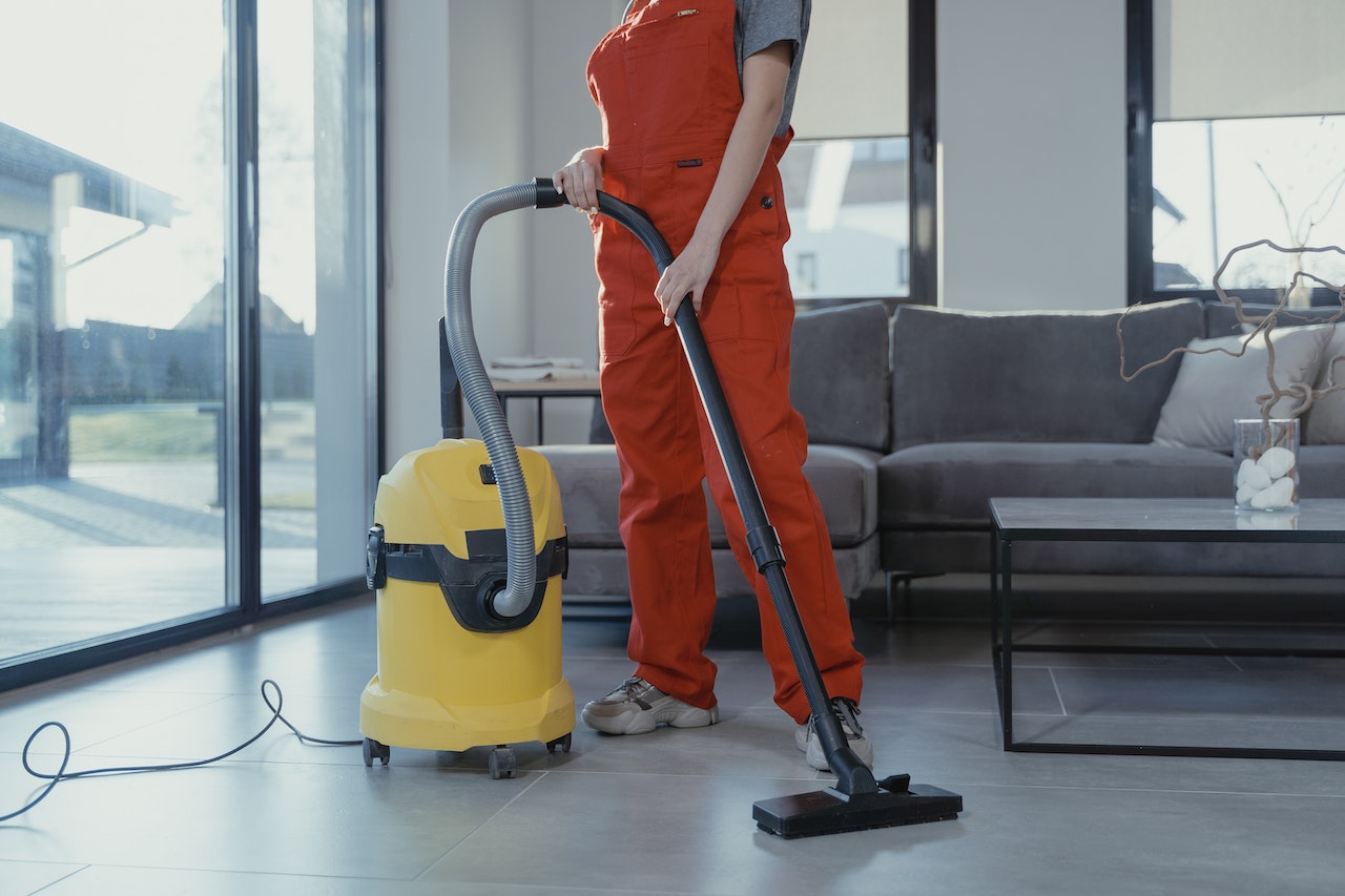 Person in orange clothing vacuuming