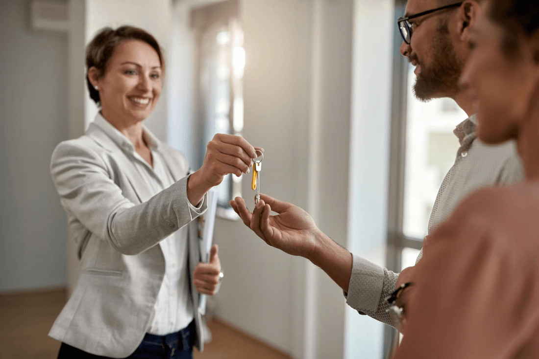 person handing over keys to a couple