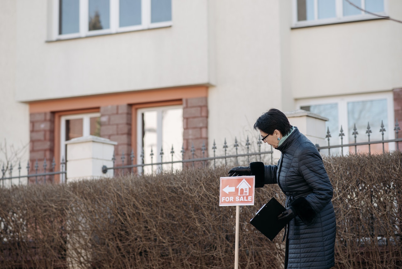 Person putting up a for sale sign